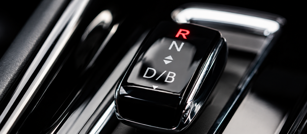 Close-up of a car gear selector with the reverse (R) illuminated in red, symbolising reverse dieting and the transition from fat loss to maintenance.