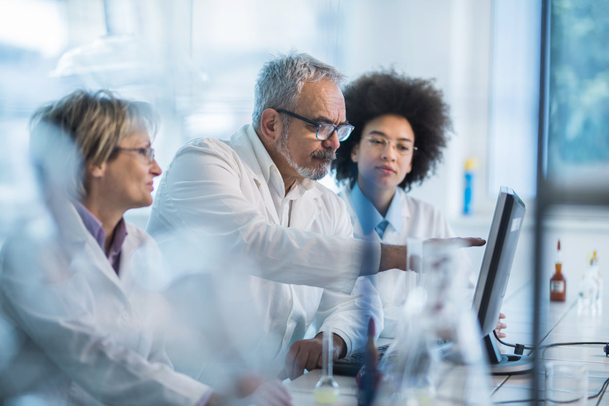 Researchers in a laboratory analysing data on screen during study of Shilajit.