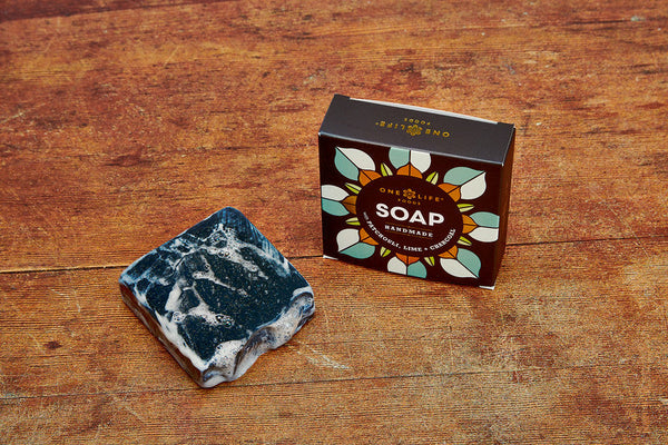 One Life Foods handmade soap and packaging displayed on a wooden surface.