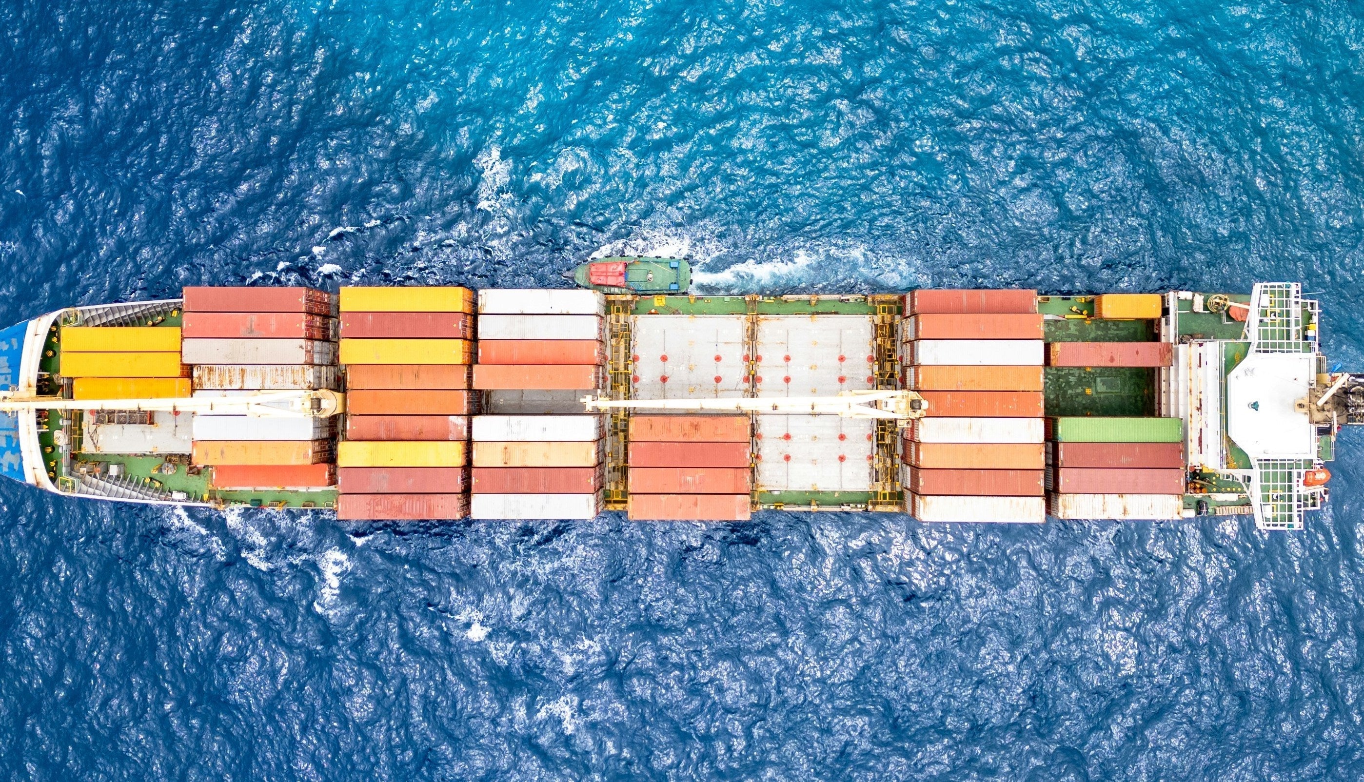 Container ship carrying cargo across open ocean, representing global supply chains