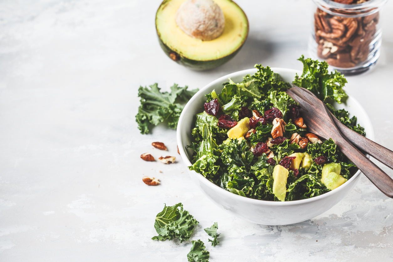 Fresh kale salad with avocado, pecans, and cranberries, symbolising gut-friendly nutrition.